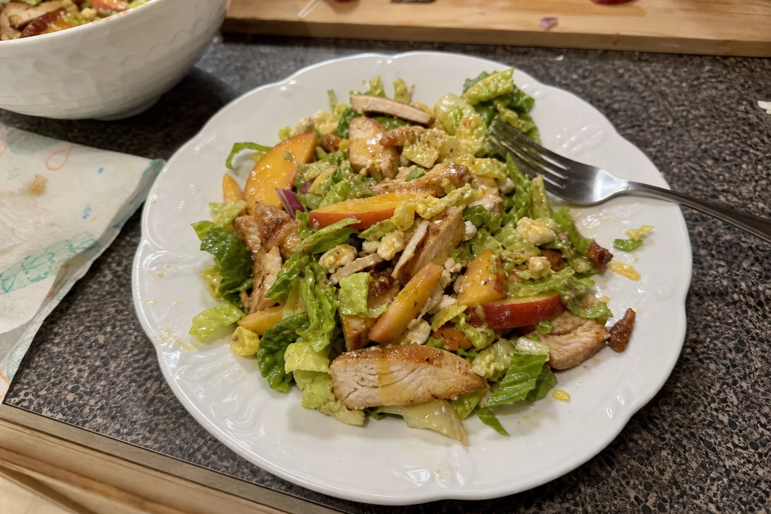 Close-up of BBQ chicken on salad with dressing.