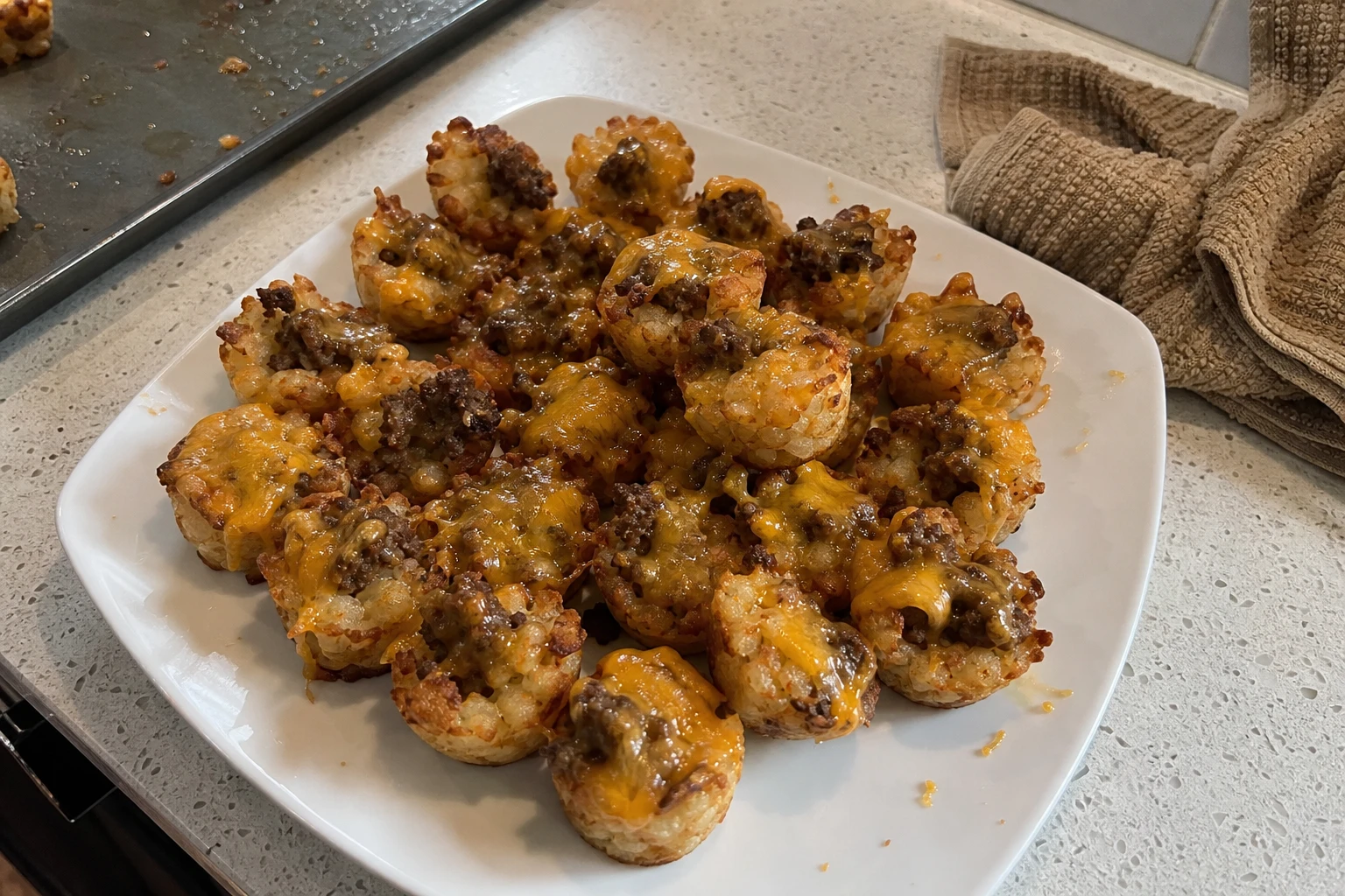 Freshly baked Beef Tater Tot Bites on a baking sheet creating a warm, inviting atmosphere