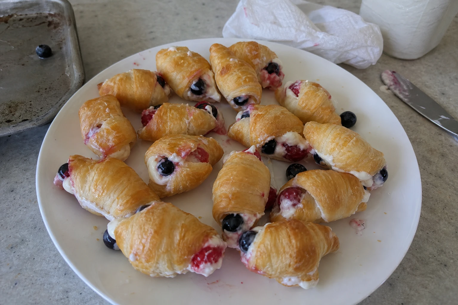 Close up of a golden croissant filled with berry cream cheese
