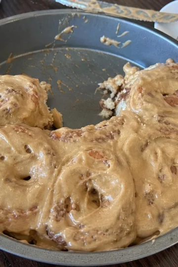 Freshly baked cinnamon rolls drizzled with cream cheese glaze