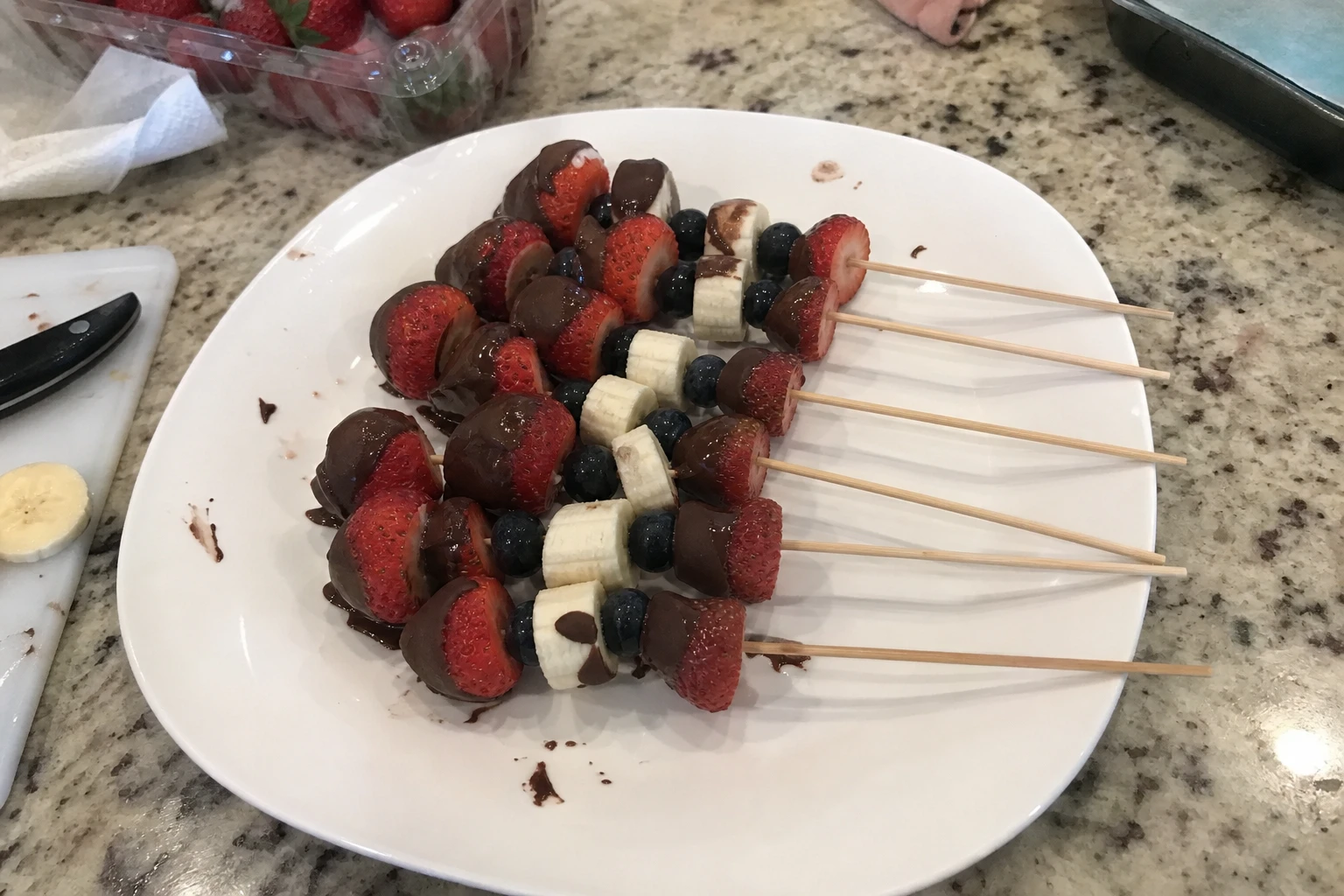 Close-up of a fresh strawberry and banana skewer dipped in chocolate, showcasing their delightful colors and textures.