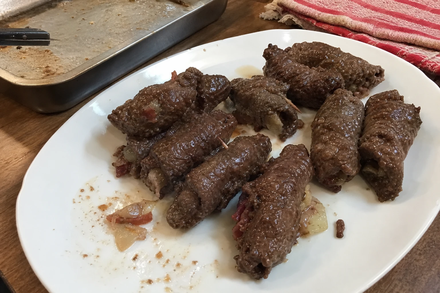 A close-up of a perfectly rolled beef roll-up with melted cheese and veggies.