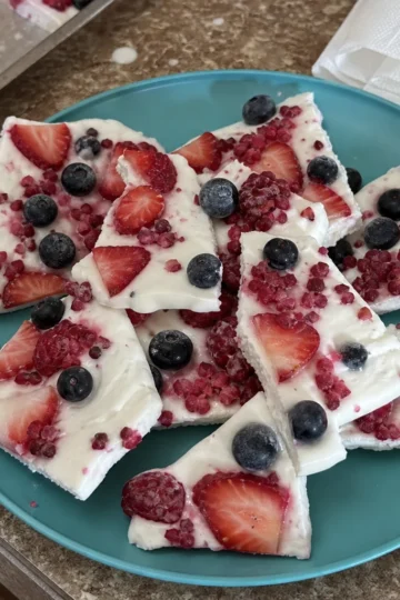 Colorful frozen yogurt bark topped with fresh summer berries.