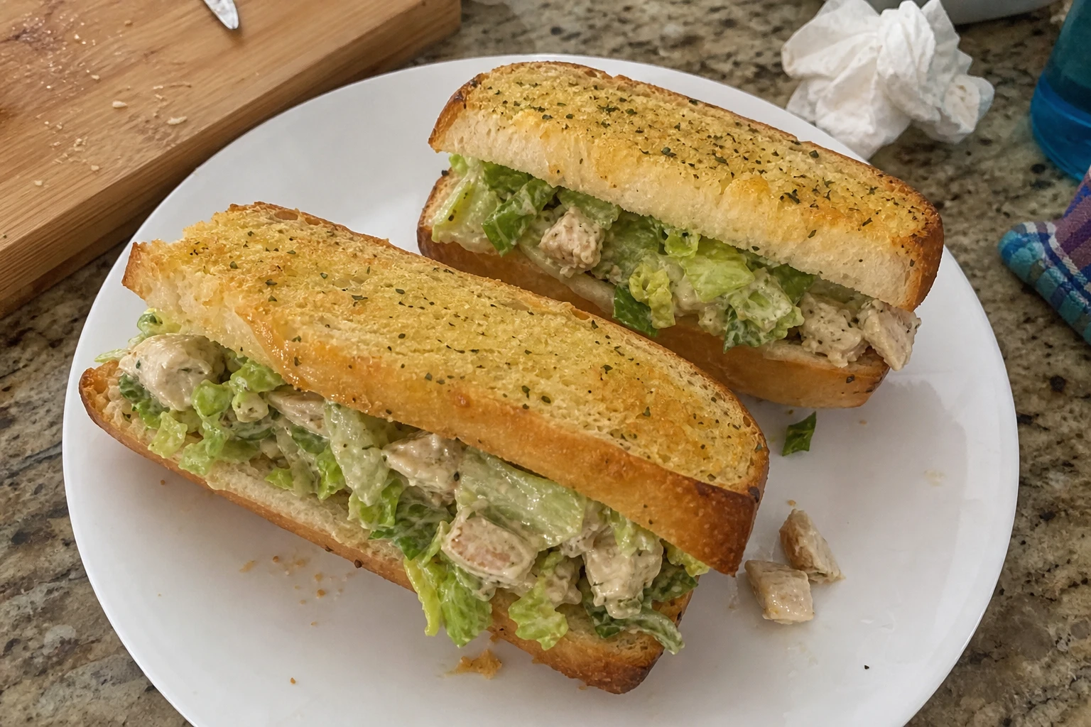 Close-up of a garlic bread chicken caesar salad sub filled with fresh ingredients