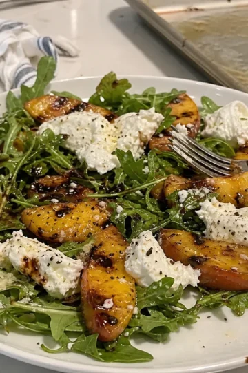 A vibrant grilled peach salad with burrata and arugula