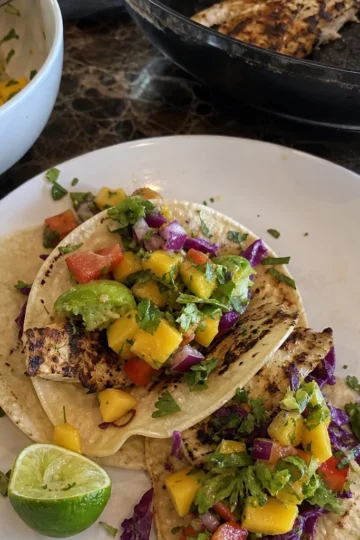 Grilled fish tacos topped with colorful mango salsa