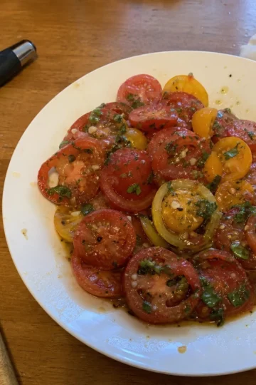 A vibrant bowl of marinated tomatoes with fresh basil