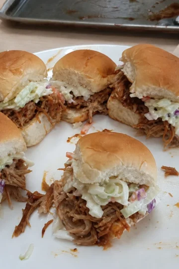 Mini BBQ pulled pork sliders held in a hand