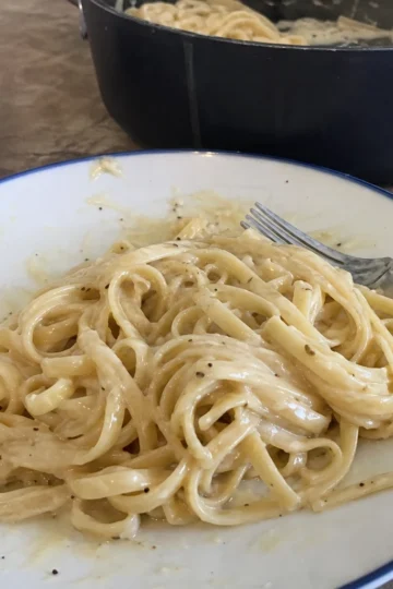 Creamy garlic pasta in a bowl garnished with parsley