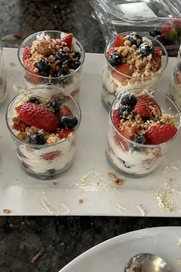 Close-up of layers in patriotic fruit parfaits featuring strawberries, blueberries, and granola.