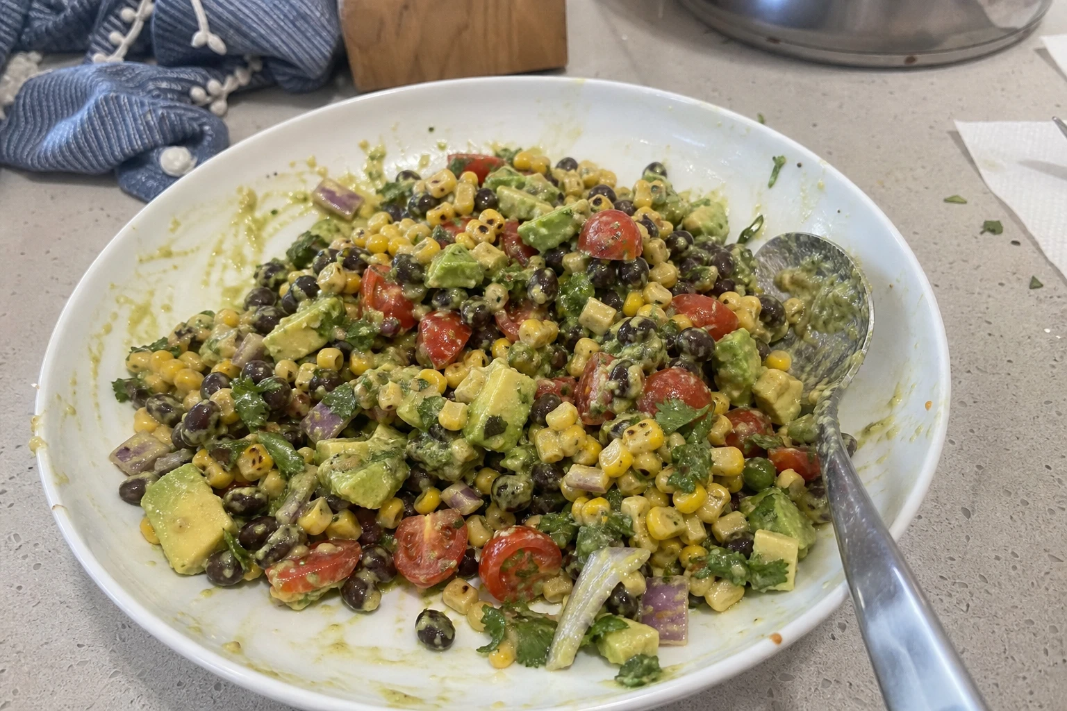 Close-up of fresh avocado dressing drizzled over corn salad