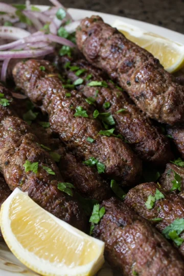 Grilled Kafta Kebabs on skewers with fresh garnish