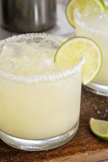 A refreshing margarita served with a lime wedge and salt rim