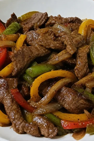 Sizzling pepper steak with colorful bell peppers on a plate
