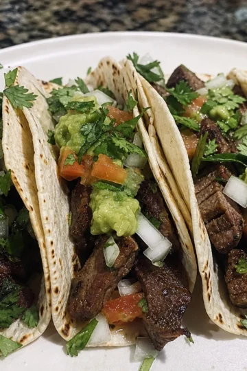 Colorful spread of steak tacos on a rustic table